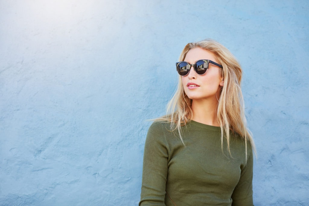 Woman in olive top wearing sunglasses