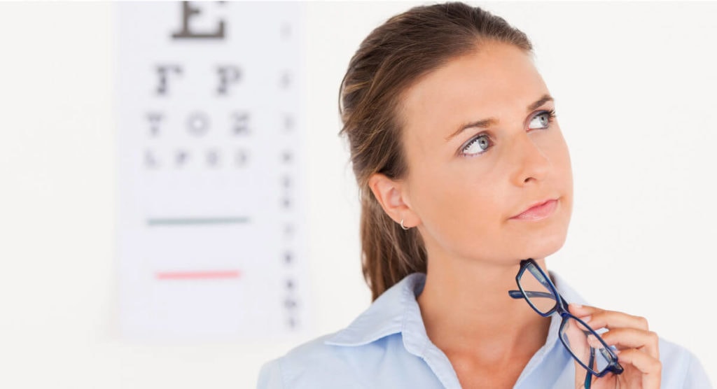 Woman pondering in front of an eye chart